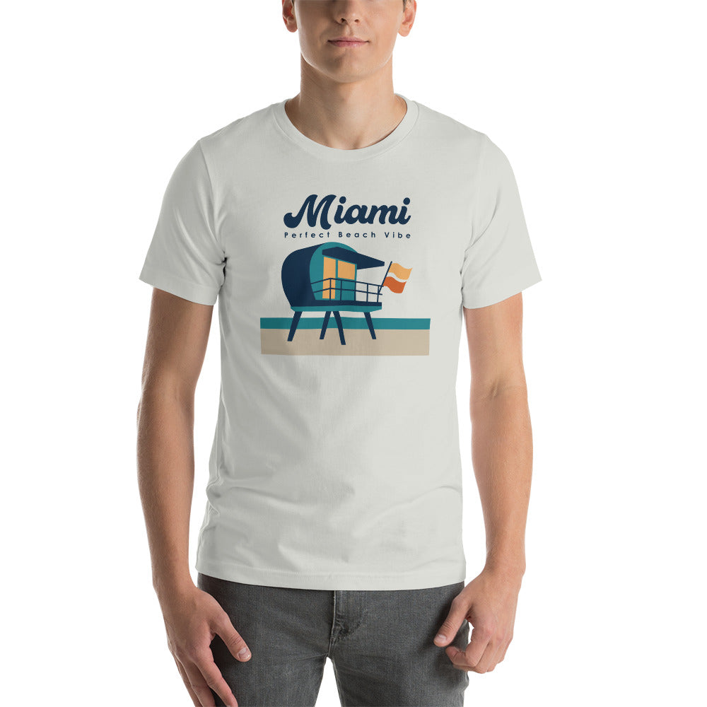 A white unisex crew neck t-shirt with 'MIAMI' printed in blue and red text on the front, featuring an illustration of a lifeguard tower.